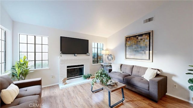 8535 Creekside Pl, Rancho Cucamonga, CA 91730 - living room featuring plenty of natural light, vaulted ceiling, wood finished floors, baseboards, and a fireplace