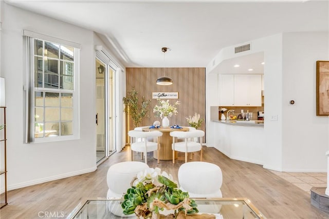 13445 Savanna, Tustin, CA 92782 - dining area with light wood-style floors, baseboards, and an accent wall