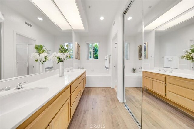 13445 Savanna, Tustin, CA 92782 - full bath featuring double vanity, a garden tub, wood finished floors, recessed lighting, and a shower stall