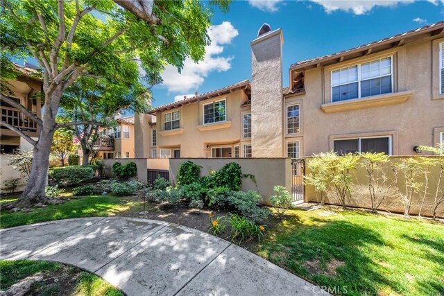 13445 Savanna, Tustin, CA 92782 - view of front of property featuring a fenced front yard, a chimney, stucco siding, and a gate