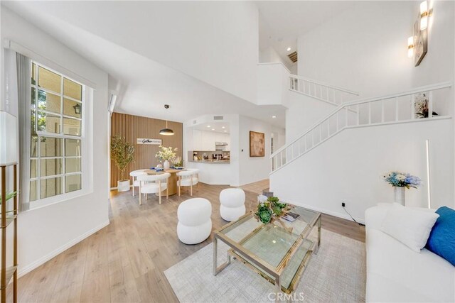 13445 Savanna, Tustin, CA 92782 - living room with light wood-style flooring, stairs, recessed lighting, a towering ceiling, and baseboards