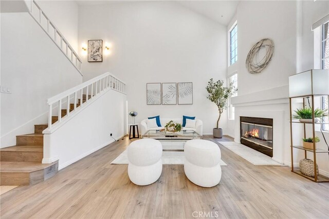 13445 Savanna, Tustin, CA 92782 - living room with high vaulted ceiling, stairs, wood finished floors, and a fireplace with flush hearth