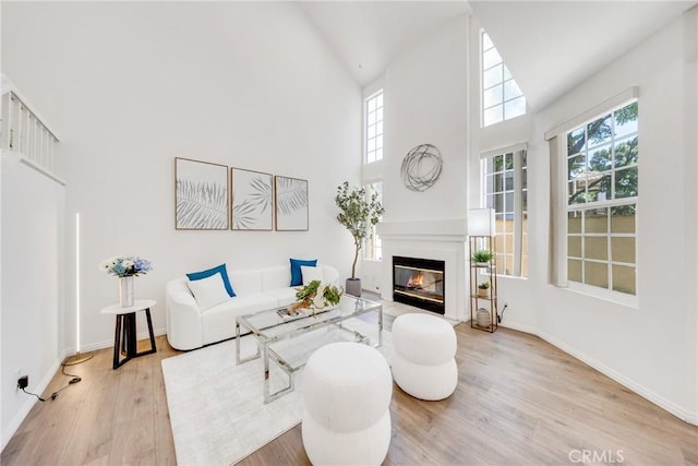 13445 Savanna, Tustin, CA 92782 - living area with wood finished floors, a glass covered fireplace, high vaulted ceiling, and baseboards