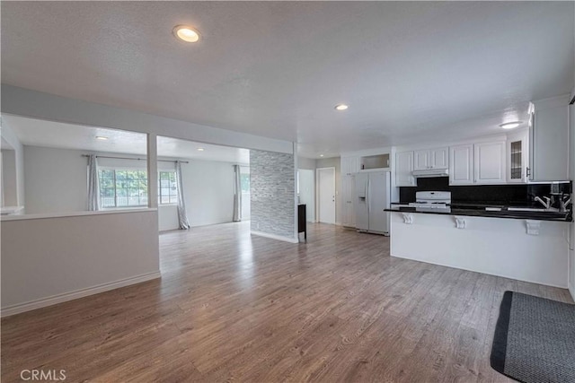 4408 Walnut Ave, Simi Valley, CA 93063 - kitchen featuring white refrigerator with ice dispenser, range, open floor plan, a peninsula, and glass insert cabinets