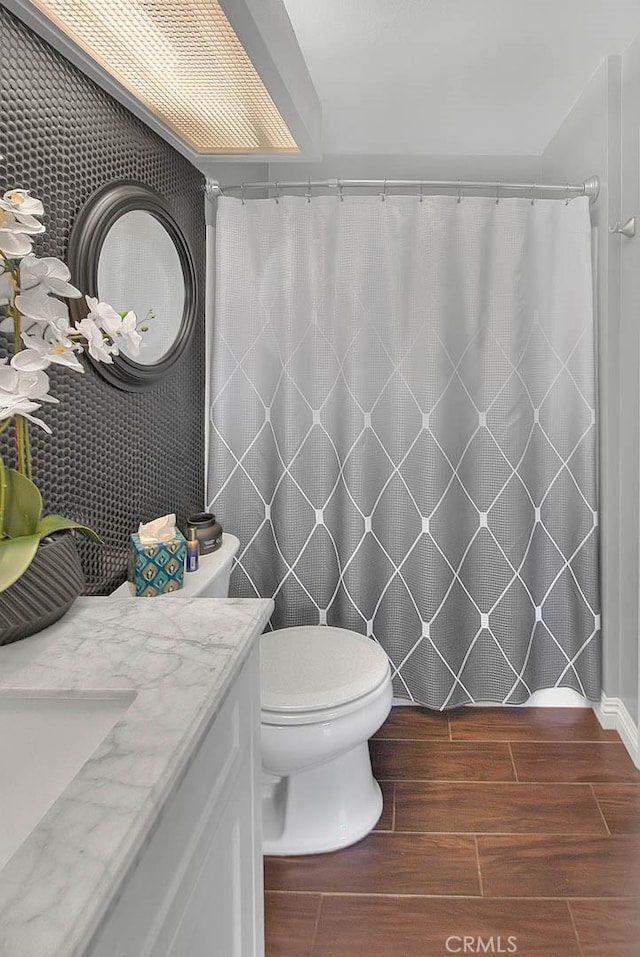 44 Carriage Way Unit 108, Pomona, CA 91766 - bathroom featuring vanity, wood finished floors, toilet, and a shower with shower curtain