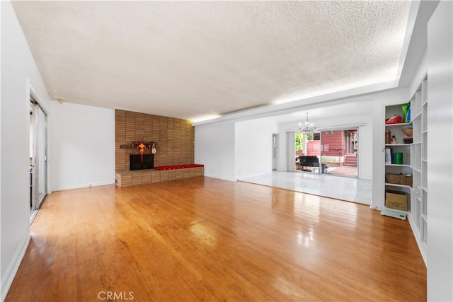 2917 W Hellman Ave, Alhambra, CA 91803 - unfurnished living room featuring a fireplace, a textured ceiling, a chandelier, and wood finished floors