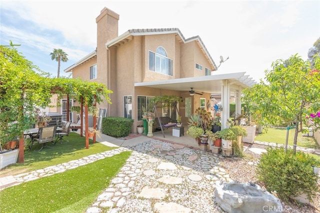13179 Lone Stallion Ln, Corona, CA 92883 - rear view of house with a ceiling fan, a patio area, stucco siding, a yard, and a chimney
