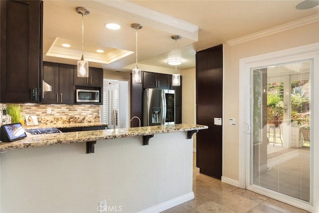 13179 Lone Stallion Ln, Corona, CA 92883 - kitchen with stainless steel appliances, crown molding, a breakfast bar area, dark brown cabinetry, and backsplash