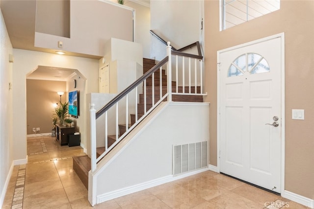13179 Lone Stallion Ln, Corona, CA 92883 - tiled entrance foyer featuring stairs, a high ceiling, baseboards, and arched walkways