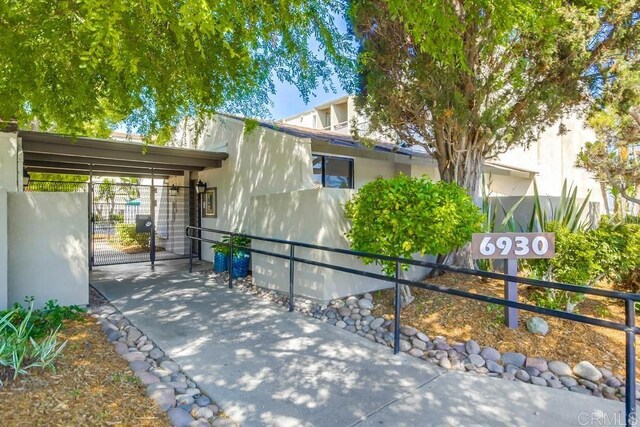 6930 Hyde Park Dr Unit 218, San Diego, CA 92119 - view of front of property featuring a gate and stucco siding
