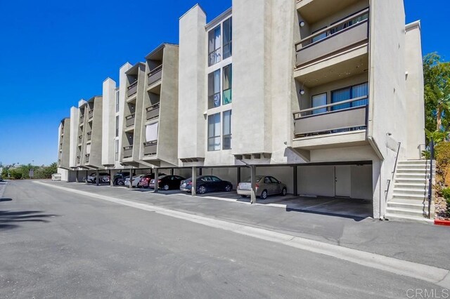 6930 Hyde Park Dr Unit 218, San Diego, CA 92119 - view of apartment building / complex featuring covered parking and stairs
