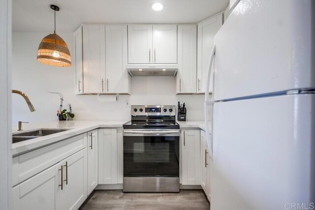 6930 Hyde Park Dr Unit 218, San Diego, CA 92119 - kitchen with freestanding refrigerator, stainless steel range with electric stovetop, a sink, under cabinet range hood, and white cabinets