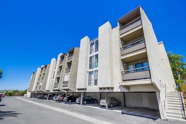 6930 Hyde Park Dr Unit 218, San Diego, CA 92119 - view of apartment building / complex featuring covered parking and stairs