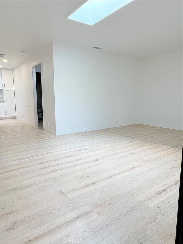 3088 Via Serena N Unit D, Laguna Woods, CA 92637 - spare room featuring light wood finished floors, a skylight, and baseboards