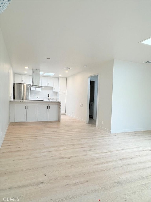 3088 Via Serena N Unit D, Laguna Woods, CA 92637 - unfurnished living room with light wood-style floors, a sink, baseboards, and recessed lighting