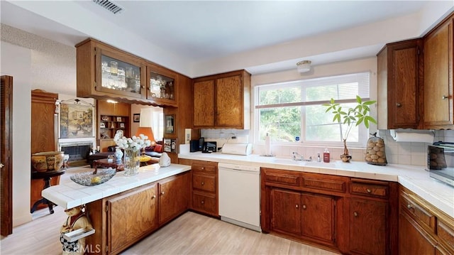 13424 Washington Ave, Hawthorne, CA 90250 - kitchen with dishwasher, brown cabinetry, a peninsula, and backsplash