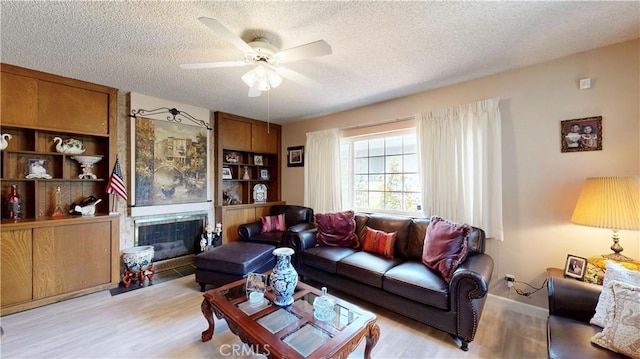 13424 Washington Ave, Hawthorne, CA 90250 - living area featuring a textured ceiling, wood finished floors, a ceiling fan, and a glass covered fireplace