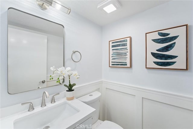7 Monticello Ln, Rancho Santa Margarita, CA 92688 - half bathroom with toilet, vanity, wainscoting, and a decorative wall