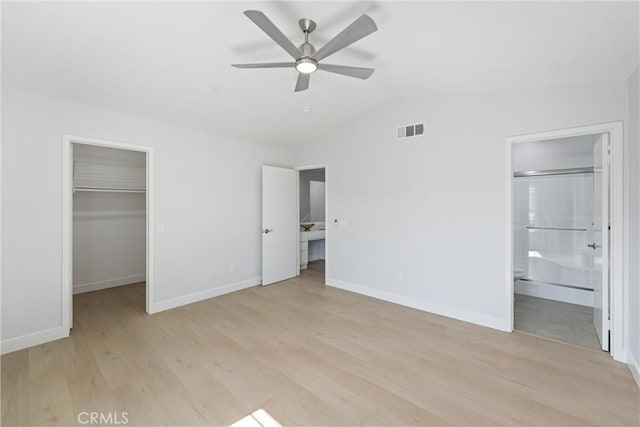 7 Monticello Ln, Rancho Santa Margarita, CA 92688 - unfurnished bedroom with a spacious closet, light wood-type flooring, vaulted ceiling, baseboards, and a closet