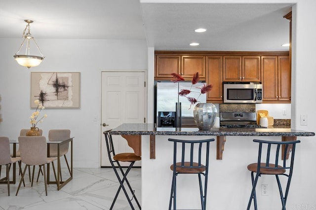 5529 Old Ranch Rd Unit 47, Oceanside, CA 92057 - kitchen with appliances with stainless steel finishes, brown cabinets, a kitchen bar, light marble finish flooring, and tasteful backsplash