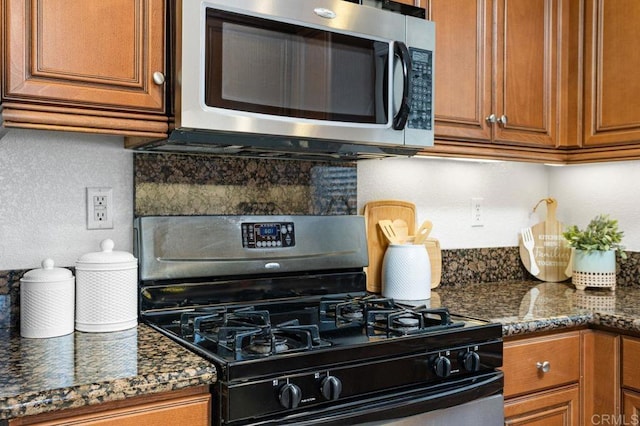 5529 Old Ranch Rd Unit 47, Oceanside, CA 92057 - kitchen featuring black gas range oven, stainless steel microwave, brown cabinets, backsplash, and dark stone counters