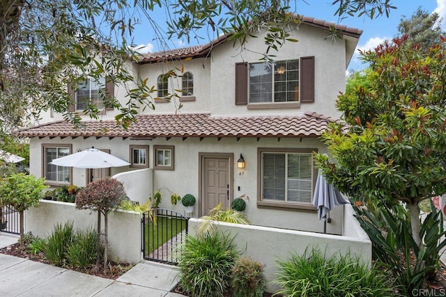5529 Old Ranch Rd Unit 47, Oceanside, CA 92057 - mediterranean / spanish-style home featuring a fenced front yard, a gate, a tiled roof, and stucco siding