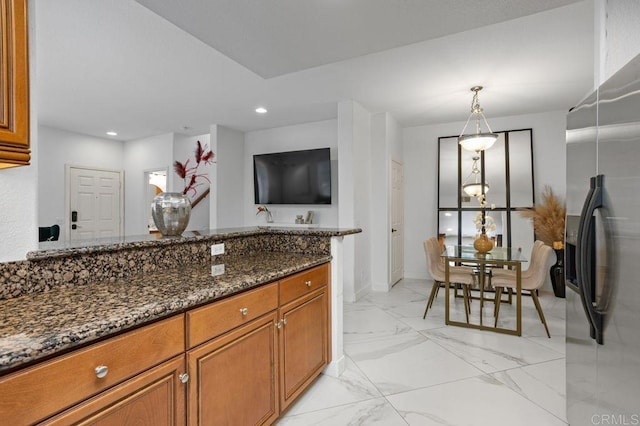 5529 Old Ranch Rd Unit 47, Oceanside, CA 92057 - kitchen with stainless steel fridge, brown cabinetry, dark stone counters, light marble finish floors, and recessed lighting