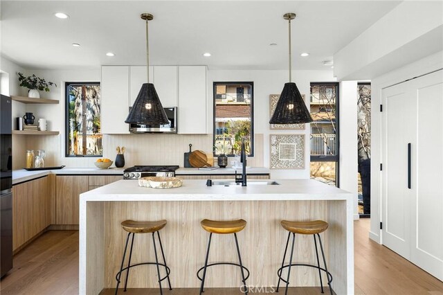 957 Everett St, Los Angeles, CA 90026 - kitchen with modern cabinets, a sink, decorative backsplash, a breakfast bar area, and recessed lighting