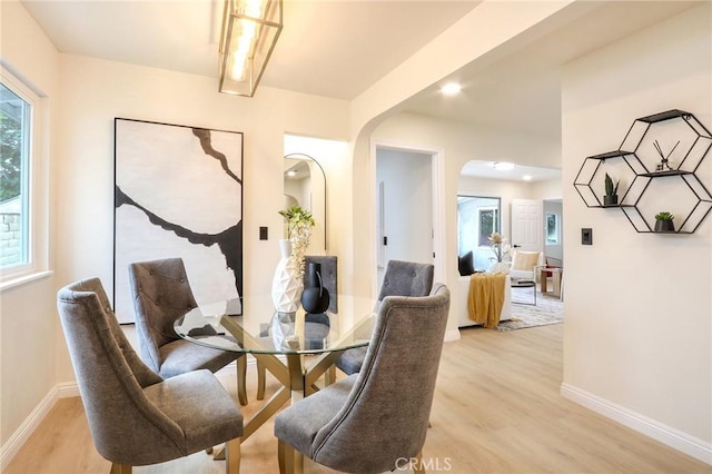 18479 Aguiro St, Rowland Heights, CA 91748 - dining room featuring arched walkways, light wood-style flooring, and baseboards