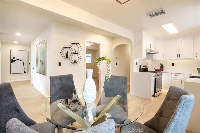 18479 Aguiro St, Rowland Heights, CA 91748 - dining space with arched walkways, light wood-style floors, and baseboards