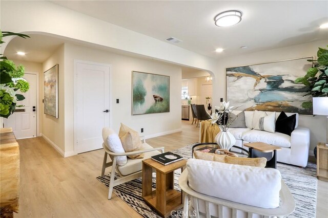 18479 Aguiro St, Rowland Heights, CA 91748 - living area featuring arched walkways, light wood-type flooring, and baseboards