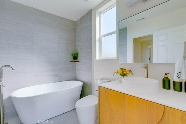 712 N Chestnut Ave, Los Angeles, CA 90042 - full bath featuring vanity, a freestanding tub, tile walls, toilet, and tile patterned floors