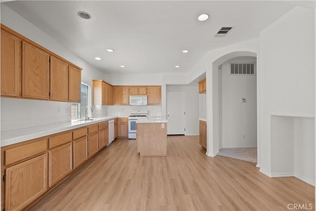 4349 Bethpage Dr, Palmdale, CA 93551 - kitchen featuring white appliances, arched walkways, light wood-style floors, a sink, and recessed lighting
