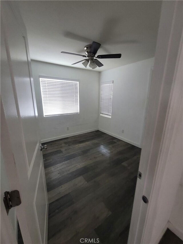 2706 E 57th St, Long Beach, CA 90805 - spare room featuring dark wood-style floors, a ceiling fan, and baseboards