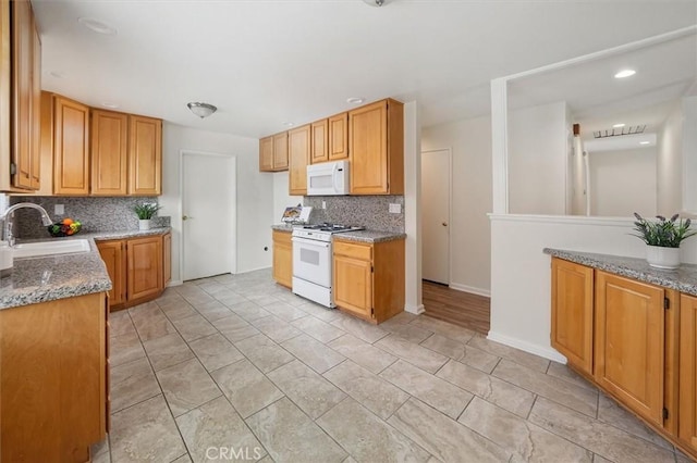 27129 Elias Ave, Saugus, CA 91350 - kitchen featuring white appliances, a sink, backsplash, light stone countertops, and baseboards