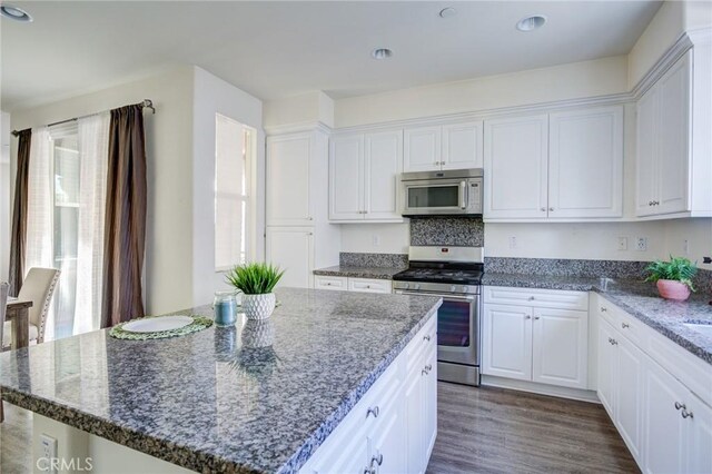 12456 Cassiopeia Ct, Eastvale, CA 91752 - kitchen featuring stainless steel range with gas cooktop, white cabinets, dark wood-type flooring, dark stone counters, and recessed lighting
