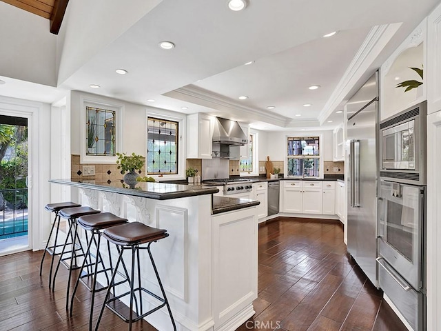 30461 Puerto Vallarta Dr, Laguna Niguel, CA 92677 - kitchen featuring a tray ceiling, a peninsula, a warming drawer, dark countertops, and built in appliances