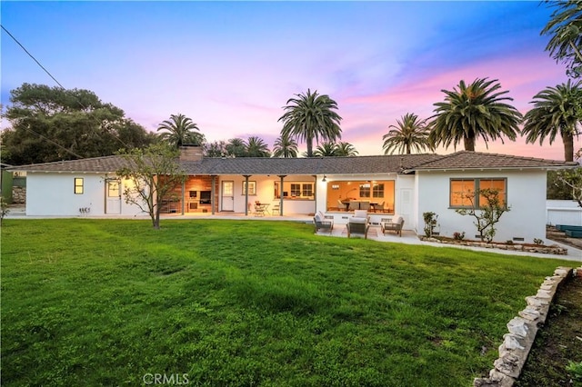 4000 Via Cardelina, Palos Verdes Estates, CA 90274 - back of property at dusk featuring an outdoor hangout area, a yard, stucco siding, and a patio area
