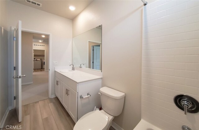 24311 Insignia Dr, Menifee, CA 92584 - full bath with vanity, wood finished floors, toilet, recessed lighting, and washer / dryer