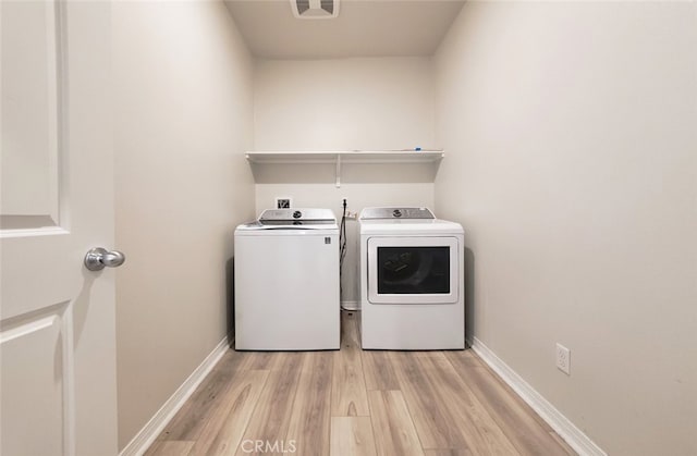 24311 Insignia Dr, Menifee, CA 92584 - laundry room with washer and dryer, light wood-style flooring, and baseboards
