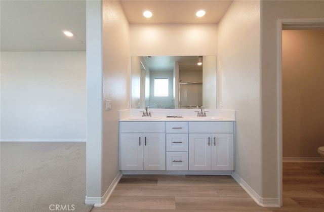 24311 Insignia Dr, Menifee, CA 92584 - bathroom featuring double vanity, toilet, wood finished floors, recessed lighting, and a shower with shower door