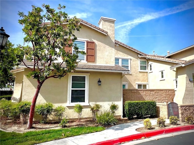 10382 Sparkling Dr Unit 2, Rancho Cucamonga, CA 91730 - view of front facade with stucco siding and a chimney
