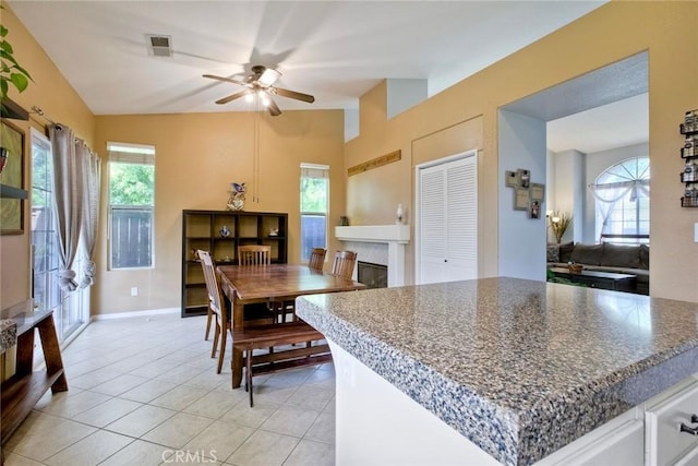 3311 Avocado Vista Ln, Fallbrook, CA 92028 - dining area featuring a ceiling fan, light tile patterned floors, healthy amount of natural light, lofted ceiling, and a fireplace