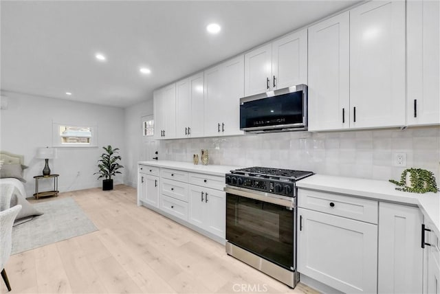 239 N San Antonio Ave, Upland, CA 91786 - kitchen featuring range with gas cooktop, stainless steel microwave, light wood-style flooring, light countertops, and white cabinets
