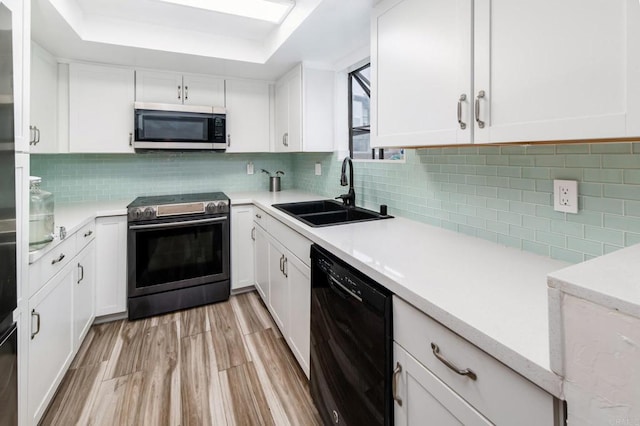 7335 Alicante Rd Unit C, Carlsbad, CA 92009 - kitchen featuring appliances with stainless steel finishes, a sink, white cabinetry, light countertops, and a tray ceiling