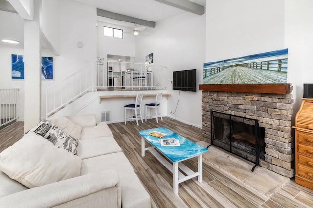 7335 Alicante Rd Unit C, Carlsbad, CA 92009 - living room with a ceiling fan, a high ceiling, wood finished floors, stairs, and a fireplace