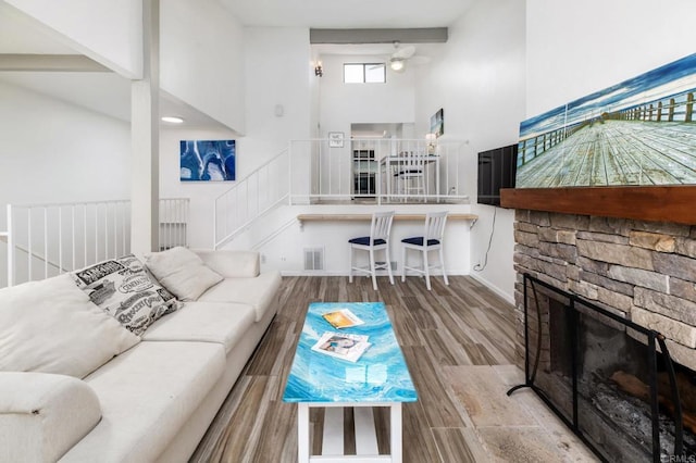 7335 Alicante Rd Unit C, Carlsbad, CA 92009 - living room with a ceiling fan, a towering ceiling, wood finished floors, stairway, and a fireplace