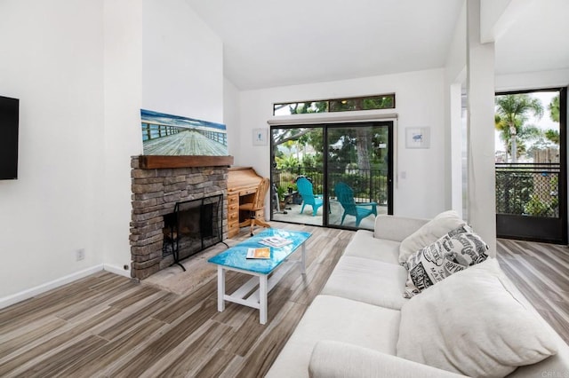 7335 Alicante Rd Unit C, Carlsbad, CA 92009 - living area featuring wood finished floors, high vaulted ceiling, a fireplace, and baseboards