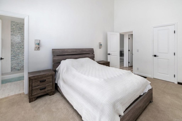 7335 Alicante Rd Unit C, Carlsbad, CA 92009 - bedroom with light carpet, a towering ceiling, baseboards, and ensuite bathroom