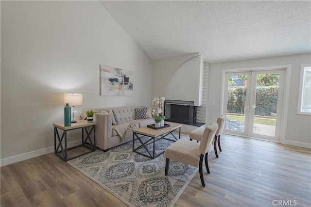 1506 W Sharon Rd, Santa Ana, CA 92706 - living room with wood finished floors, baseboards, a textured ceiling, a fireplace, and vaulted ceiling